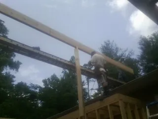 Carpenter setting a ridge beam over a new addition frame — Ice Dam Removal by Roofing Brothers in Lebanon